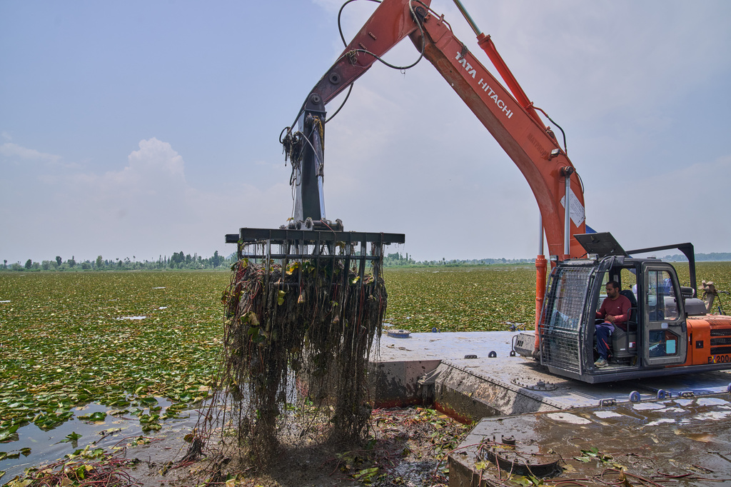 An employee of the Lake Conservation and Management Authority (LCMA) uses a machine to clear weeds from Dal Lake in Srinagar, Indian controlled Kashmir, Wednesday, May 20, 2026. (AP Photo/Dar Yasin)