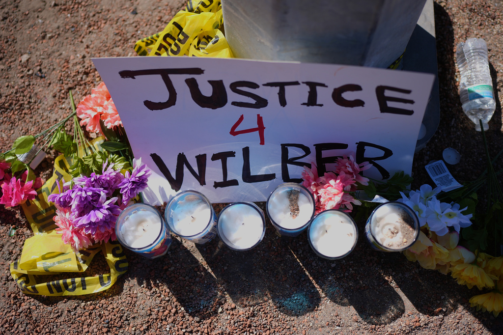 Flowers and candles are seen near the site where a Venezuelan man was shot in his vehicle by an ICE officer in Austin, Texas, Monday, Sept. 21, 2026. (AP Photo/Eric Gay)