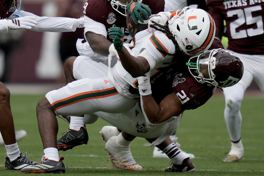 Miami wide receiver Malachi Toney (10) is tackled after a short run by Texas A&M linebacker Taurean York (21) during the first quarter in the first round of the NCAA College Football Playoff, Saturday, Dec. 20, 2025, in College Station, Texas. (AP Photo/Sam Craft)