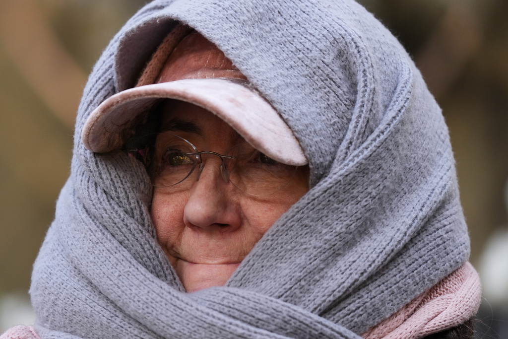 A woman bundles up during a cold day in Chicago, Tuesday, Nov. 11, 2025. (AP Photo/Nam Y. Huh)