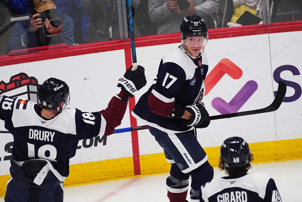 Colorado Avalanche center Parker Kelly (17) celebrates after scoring with center Jack Drury, left, and defenseman Samuel Girard, bottom right, in the third period of an NHL hockey game against the Winnipeg Jets, Friday, Dec. 19, 2025, in Denver. (AP Photo/David Zalubowski)