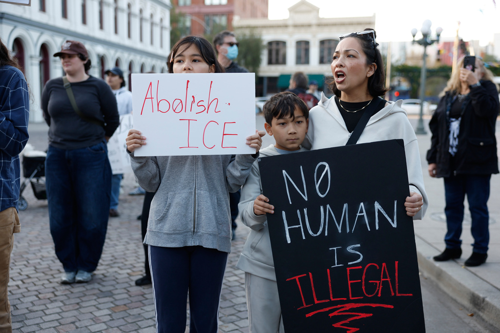 Demonstrators hold signs during a protest in response to the fatal shooting of 37-year-old Alex Pretti in Minneapolis earlier in the day Saturday, Jan. 24, 2026, in Los Angeles. (AP Photo/Caroline Brehman)