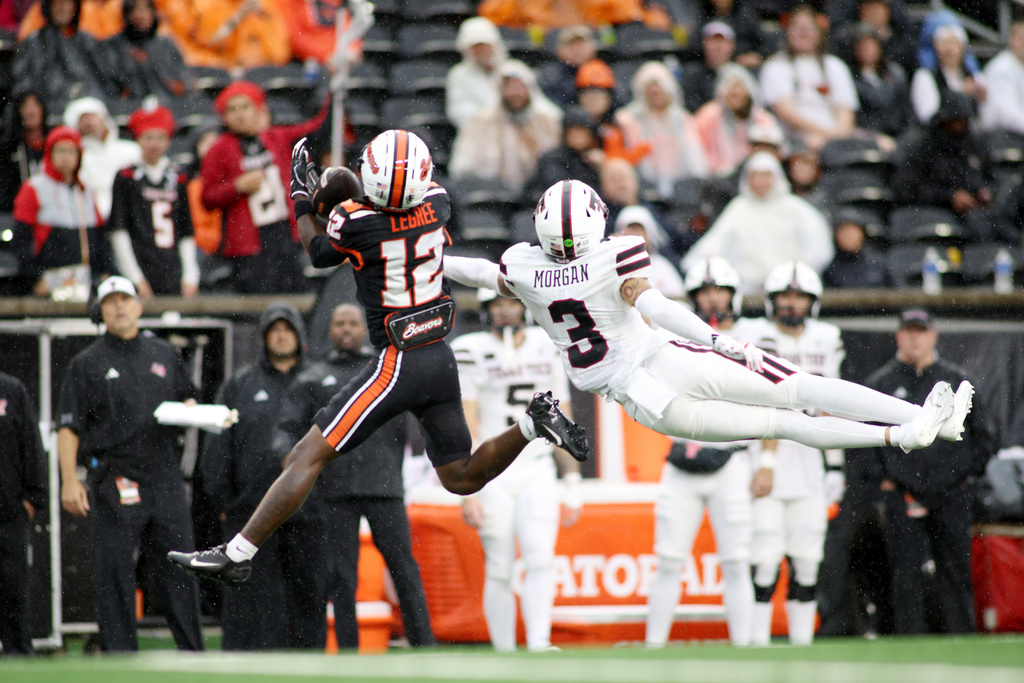 Oregon State wide receiver Jesse Legree (12) catches a pass while guarded by Texas Tech defensive back Peyton Morgan (3) on a touchdown play during the first half of an NCAA college football game, Saturday, Sept. 12, 2026, in Corvallis, Ore. (AP Photo/Lydia Ely) CORRECTION: Corrects to Oregon State wide receiver Jesse Legree (12) catches a pass while guarded by Texas Tech defensive back Peyton Morgan (3) not Texas Tech defensive back Tarrion Grant (12) intercepts a pass to Oregon State running back Cornell Hatcher Jr. (3).