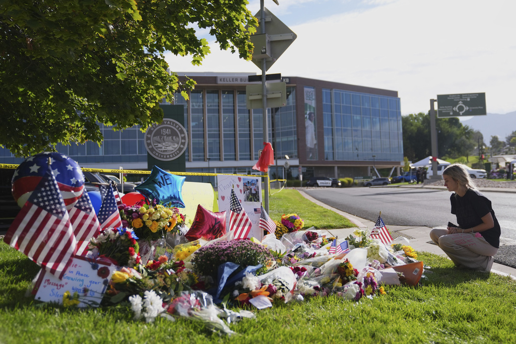 Meagan Bradley kneels at a memorial is set up for Charlie Kirk at Utah Valley University in Orem, Utah, Friday, Sept. 12, 2025. (AP Photo/Lindsey Wasson)
