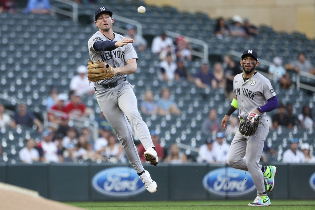 New York Yankees third baseman Ryan McMahon, left, throws to first base to put out Minnesota Twins' Luke Keaschall during the first inning of baseball game Monday, Sept. 15, 2025, in Minneapolis. (AP Photo/Matt Krohn)