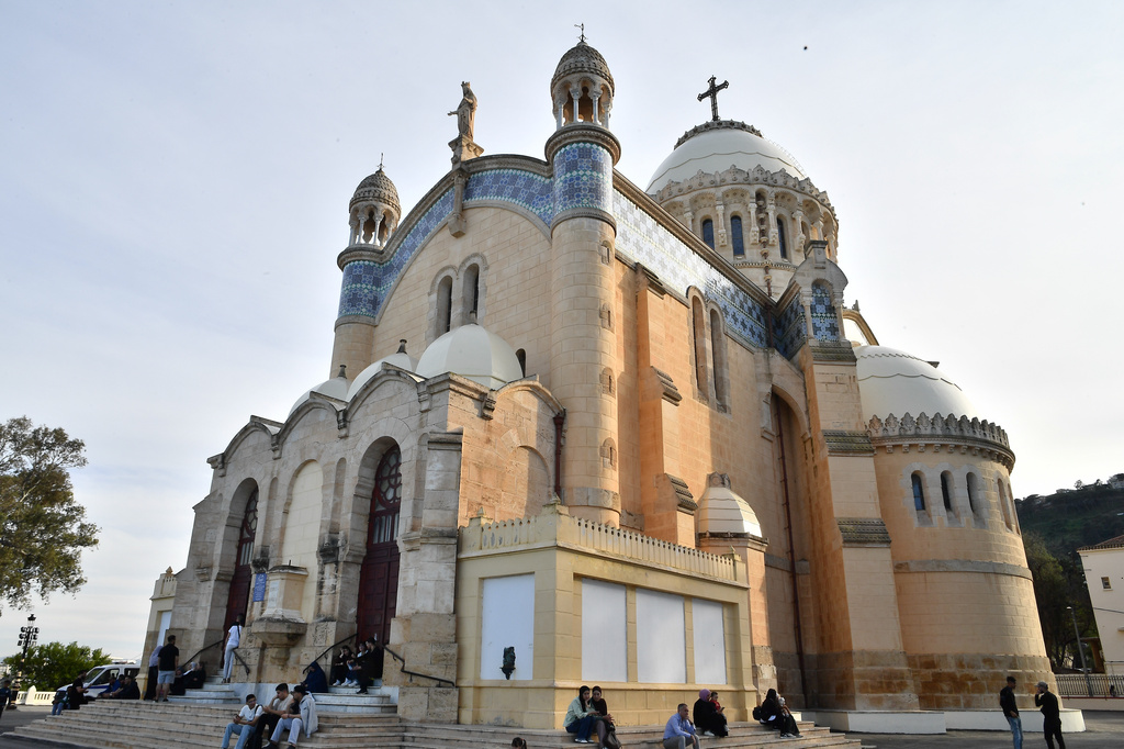 People sit outside the Church of Notre Dame d'Afrique, ahead of Pope Leo XIV's visit, in Algiers, Algeria, Wednesday, April 8, 2026. (AP Photo/Fateh Guidoum)