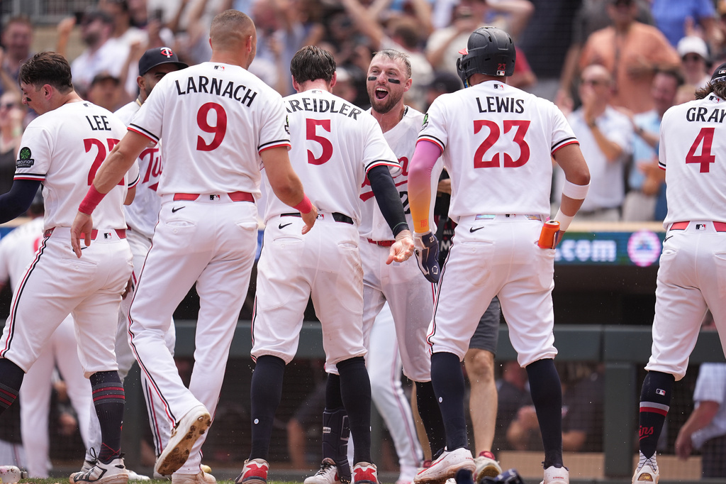 Minnesota Twins' Kody Clemens, back, middle, celebrates with teammates after hitting a walk-off grand slam during the ninth inning of a baseball game against the Kansas City Royals Thursday, July 30, 2026, in Minneapolis. (AP Photo/Abbie Parr)