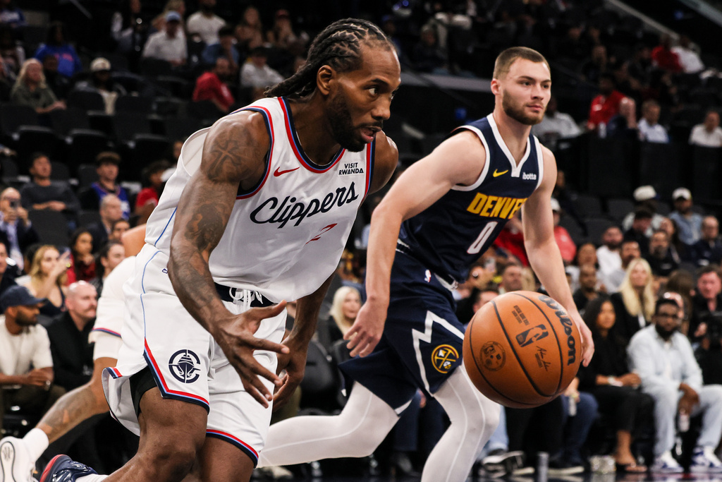 Los Angeles Clippers forward Kawhi Leonard, left, captures a rebound against Denver Nuggets guard Christian Braun during the first half of a preseason NBA basketball game, Sunday, Oct. 12, 2025, in Inglewood, Calif. (AP Photo/Etienne Laurent)