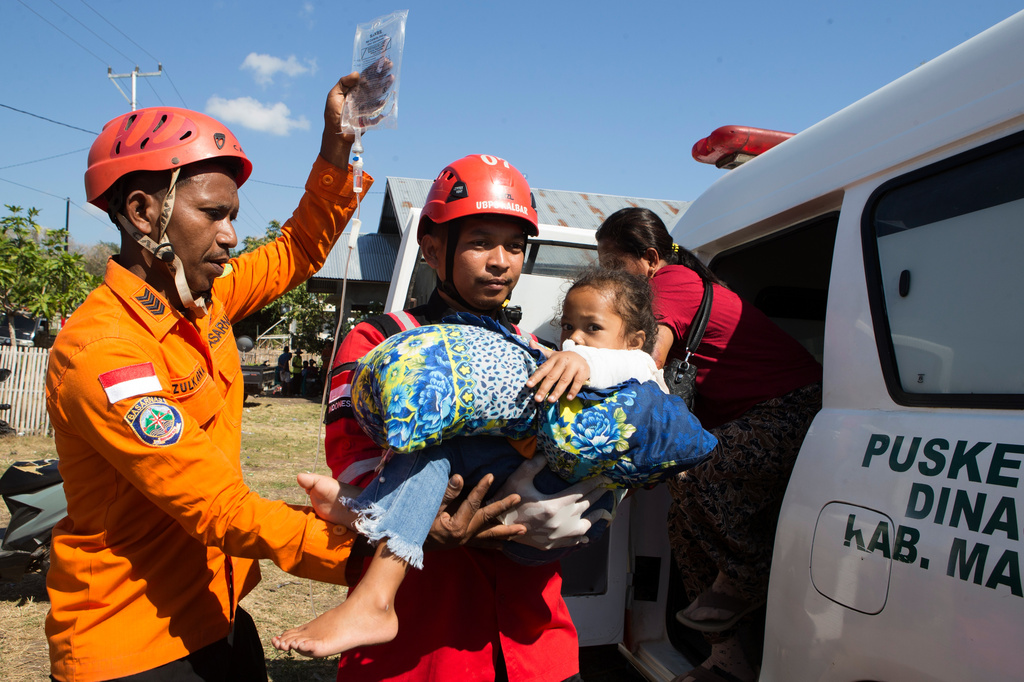 Rescuers carry a young earthquake survivor into an ambulance in North Lamba Leda, East Nusa Tenggara province, Indonesia, Tuesday, Aug. 18, 2026. (AP Photo/Firdia Lisnawati)