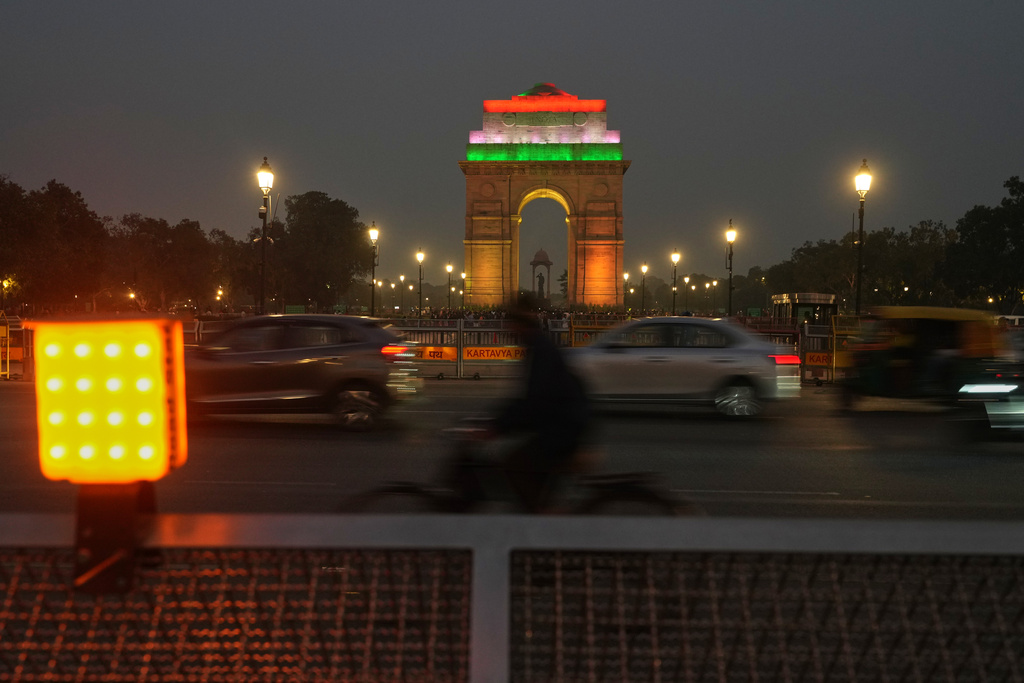 Traffic moves in front of the landmark India Gate on a smog-covered evenng in New Delhi, India, Tuesday, Nov. 18, 2025. (AP Photo/Manish Swarup)