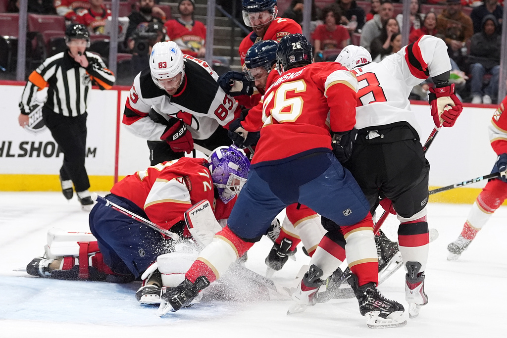 Florida Panthers goaltender Sergei Bobrovsky (72) and defensemen Jeff Petry (2) and Uvis Balinskis battle with New Jersey Devils wings Juho Lammikko (83) and Ondrej Palat (18) in front of the net during the first period of an NHL hockey game, Thursday, Nov. 20, 2025, in Sunrise, Fla. (AP Photo/Rebecca Blackwell)