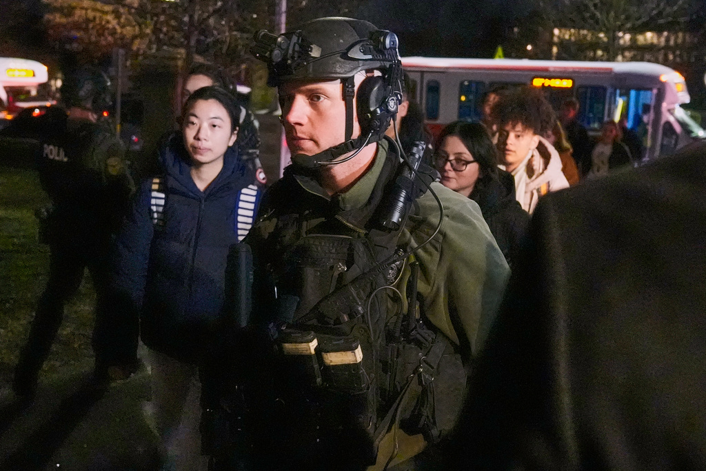 Students are escorted by law enforcement officers to a building at Brown University after a shooting, Saturday, Dec. 13, 2025, in Providence, R.I.. (AP Photo/Charles Krupa)