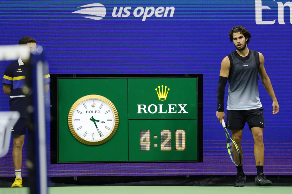 The clock reads 3:21 a.m. as Carlos Alcaraz, of Spain, plays in the fifth set against Ben Shelton, of the United States, during the quarterfinal round of the U.S. Open tennis championships, early Wednesday, Sept. 9, 2026, in New York. (AP Photo/Adam Hunger)