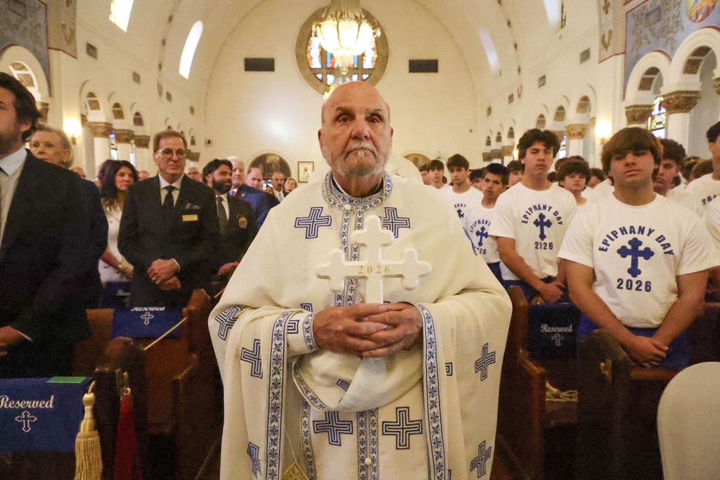 Fr. Michael Kouremetis transports the Epiphany Cross into the Saint Nicholas Greek Orthodox Cathedral while participating in the 120th Epiphany celebration on Tuesday, Jan 6, 2026, in Tarpon Springs, Fla. (Jefferee Woo /Tampa Bay Times via AP)