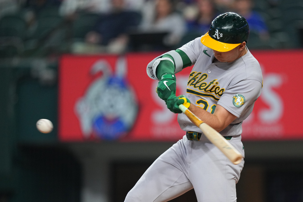 Athletics' Tyler Soderstrom swings at a pitch from Texas Rangers starting pitcher Nathan Eovaldi while connecting on a solo home run during the first inning of a baseball game Friday, April 24, 2026, in Arlington, Texas. (AP Photo/Julio Cortez)