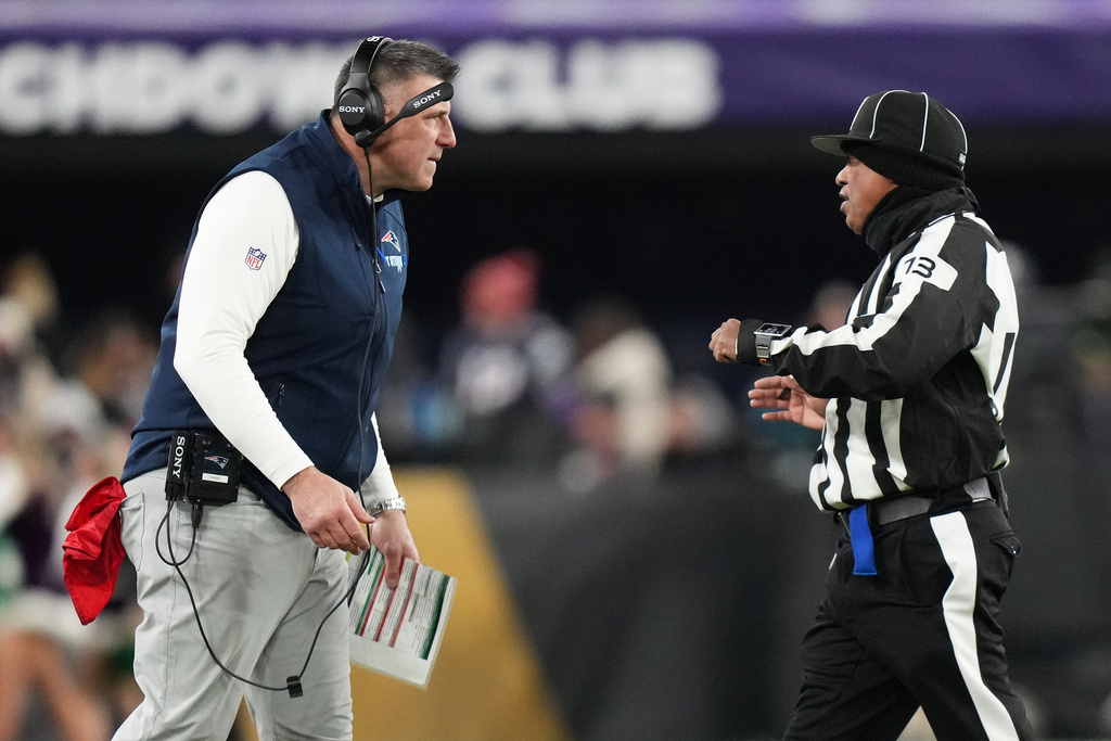 New England Patriots head coach Mike Vrabel, left, reacts toward down judge Patrick Turner (13) during the first half of an NFL football game against the Baltimore Ravens, Sunday, Dec. 21, 2025, in Baltimore. (AP Photo/Stephanie Scarbrough)