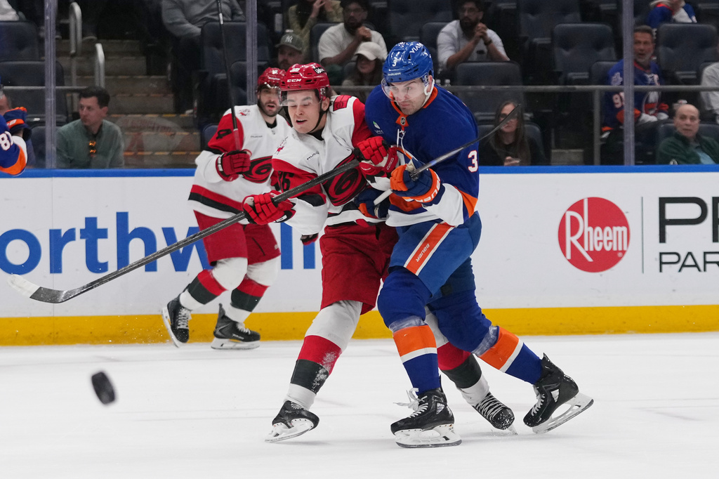 New York Islanders' Adam Pelech (3) checks Carolina Hurricanes' Felix Unger Sorum (36) during the first period of an NHL hockey game Tuesday, April 14, 2026, in Elmont, N.Y. (AP Photo/Frank Franklin II)