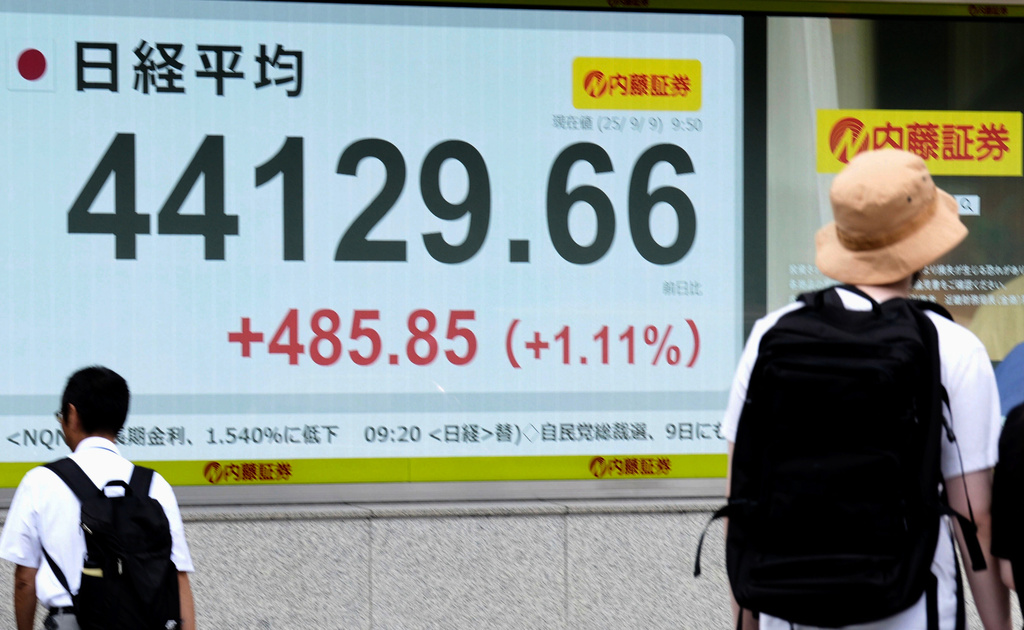 People move past an electronic stock board showing Japan's Nikkei index at a securities firm Tuesday, Sept. 9, 2025, in Tokyo. (Kyodo News via AP)