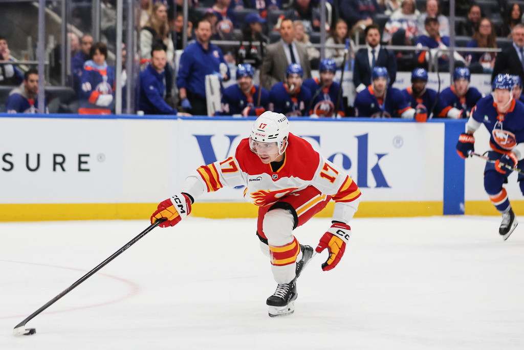 Calgary Flames center Yegor Sharangovich (17) reaches for the puck during the first period of an NHL hockey game against the New York Islanders, Saturday, March 14, 2026, in Elmont, N.Y. (AP Photo/Heather Khalifa)