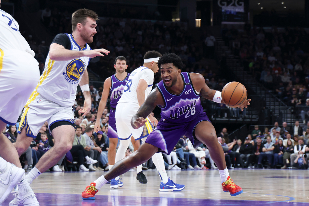 Utah Jazz forward Brice Sensabaugh (28) steps back to shoot against Golden State Warriors guard Pat Spencer (61) during the first half of an NBA basketball game, Monday, March 9, 2026, in Salt Lake City. (AP Photo/Rob Gray)