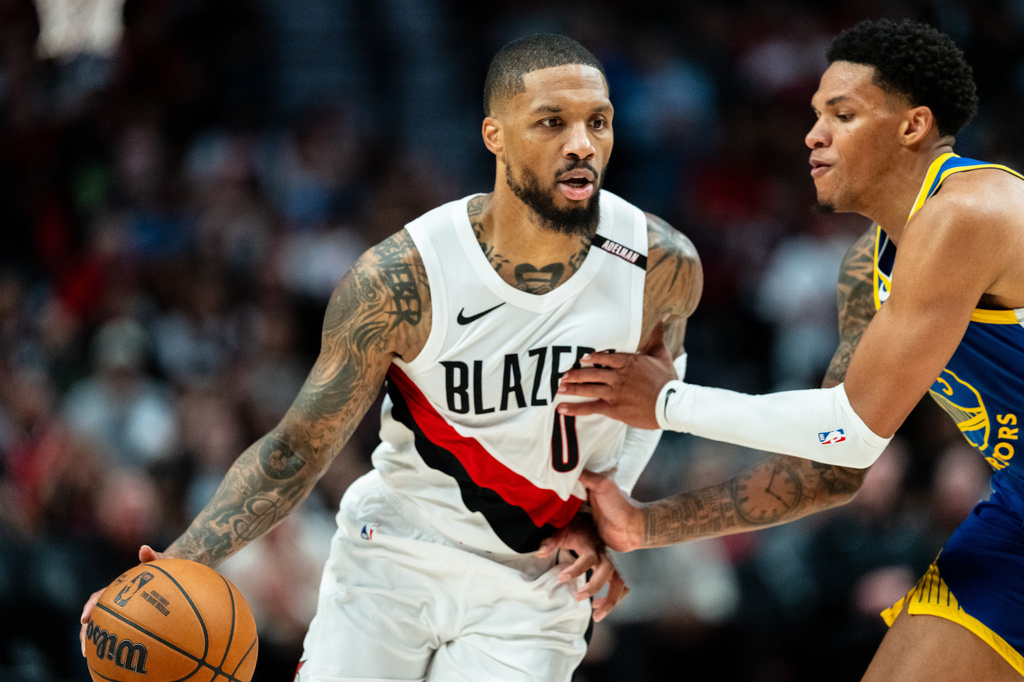 Portland Trail Blazers guard Damian Lillard (0) brings the ball up the court against Golden State Warriors guard Will Richard, right, during the first half of a preseason NBA basketball game on Wednesday, Oct. 7, 2026, in Portland, Ore. (AP Photo/Ali Gradischer)