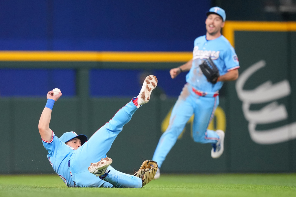 Texas Rangers outfielder Sam Haggerty makes a sliding catch on a ball hit by Athletics' Tyler Soderstrom during the seventh inning of a baseball game Sunday, April 26, 2026, in Arlington, Texas. (AP Photo/Julio Cortez)