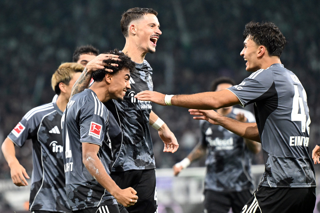 Frankfurt's Robin Koch, top, celebrates scoring with teammates during the Bundesliga soccer match between Borussia Mönchengladbach and Eintracht Frankfurt at Stadion im Borussia-Park, Mönchengladbach, Germany, Saturday Sept. 27, 2025. (Federico Gambarini/dpa via AP)