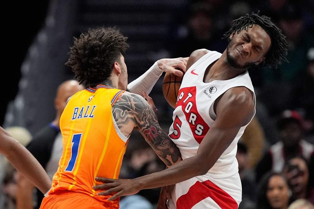 Charlotte Hornets guard LaMelo Ball collides with Toronto Raptors guard Immanuel Quickley during the first half of an NBA basketball game, Saturday, Nov. 29, 2025, in Charlotte, N.C. (AP Photo/Chris Carlson)