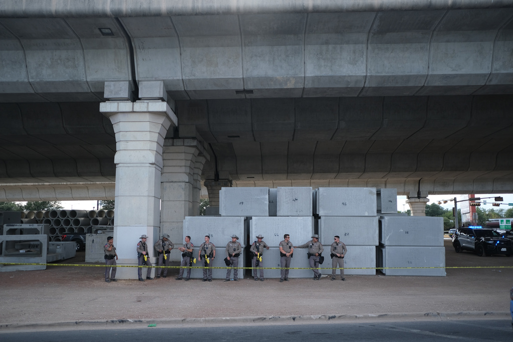Texas state troopers stand behind police tape at the site where local authorities say a U.S. Immigration and Customs Enforcement officer (ICE) shot and wounded a man in Austin, Texas, Sunday, Sept. 20, 2026. (AP Photo/Joel Angel Juarez)