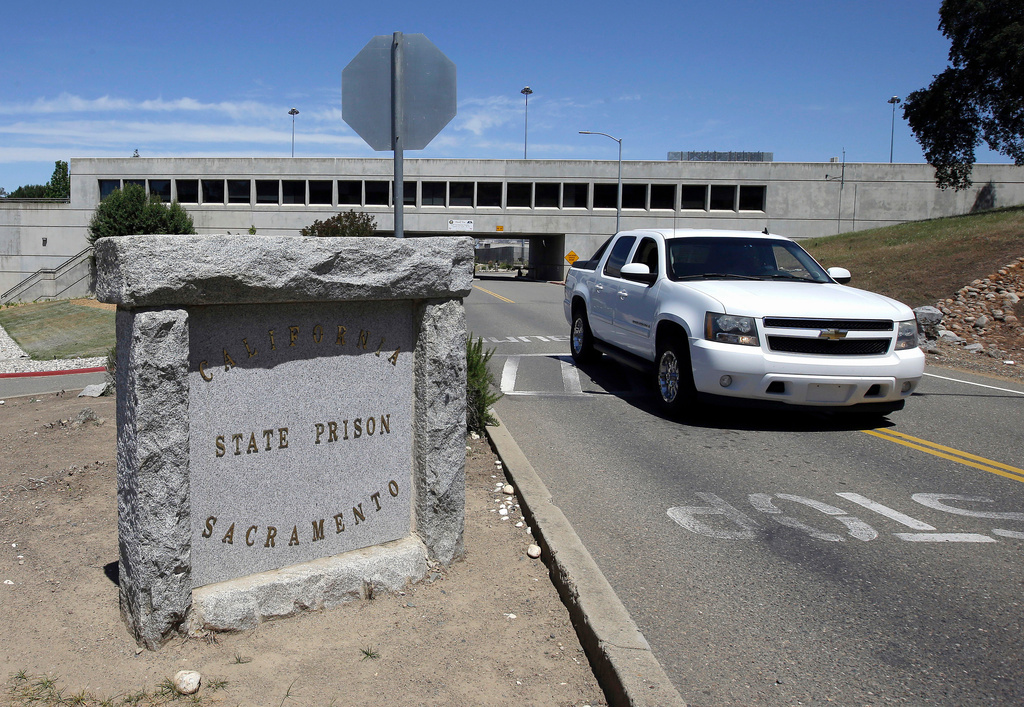 FILE - A vehicle drives by the main entrance to California State Prison, Sacramento, May 16, 2016, in Folsom, Calif. (AP Photo/Rich Pedroncelli, File)