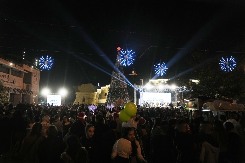 Palestinians take part in a Christmas tree–lighting event in Manger Square, next to the Church of the Nativity, traditionally regarded as the birthplace of Jesus Christ ahead of Christmas in the West Bank city of Bethlehem Saturday, Dec. 6, 2025. (AP Photo/Mahmoud Illean)
