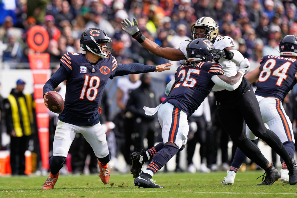 Chicago Bears quarterback Caleb Williams (18) scrambles under pressure from New Orleans Saints defensive end Chris Rumph II (58) in the second half of an NFL football game, Sunday, Oct. 19, 2025, in Chicago. (AP Photo/Nam Huh)