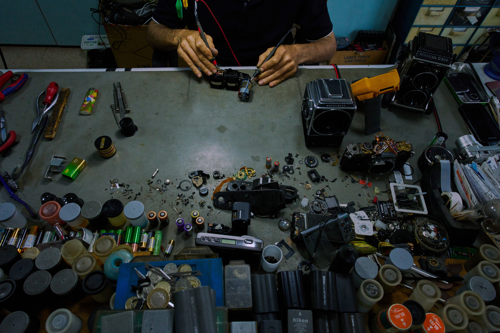 Camera repair artisan Ata Çetinkaya works in his shop in Istanbul's Sirkeci commercial district, Saturday, Aug. 8, 2026. (AP Photo/Francisco Seco)