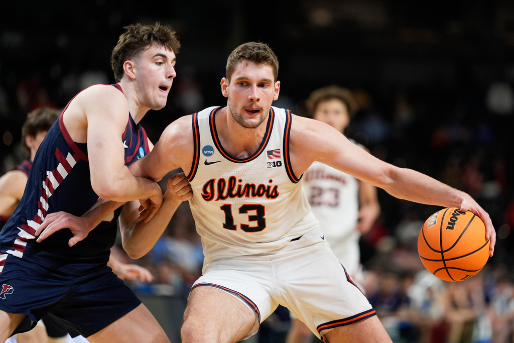 Illinois center Tomislav Ivisic drives to the basket past Pennsylvania center Dalton Scantlebury during the second half in the first round of the NCAA college basketball tournament, Thursday, March 19, 2026, in Greenville, S.C. (AP Photo/Chris Carlson)