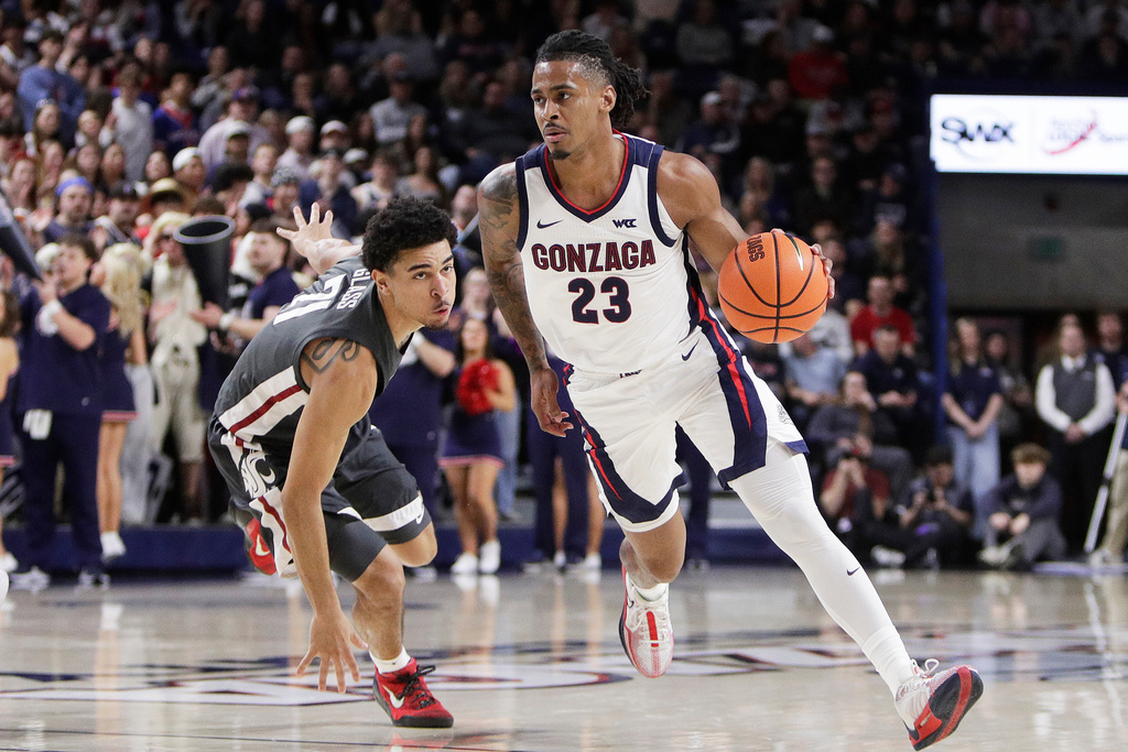 Gonzaga guard Adam Miller (23) drives while pressured by Washington State guard Ace Glass III (21) during the first half of an NCAA college basketball game, Tuesday, Feb. 10, 2026, in Spokane, Wash. (AP Photo/Young Kwak)