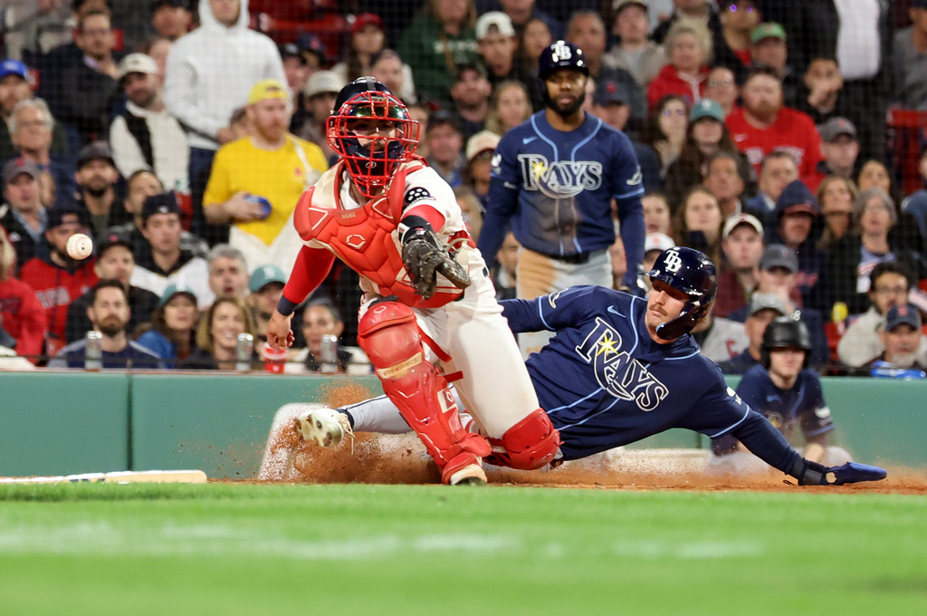 Boston Red Sox catcher Connor Wong, left, misses the throw as Tampa Bay Rays' Jonny DeLuca, right, scores during the sixth inning of a baseball game, Thursday, May 7, 2026, in Boston. (AP Photo/Mark Stockwell)