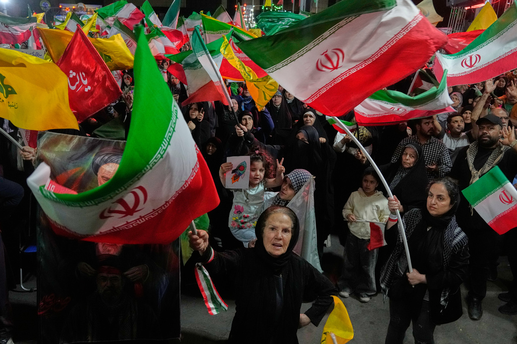 Pro-government Iranian demonstrators wave flags from Iran and Lebanon's Hezbollah in Tehran, Iran, Sunday, June 7, 2026. (AP Photo/Vahid Salemi)