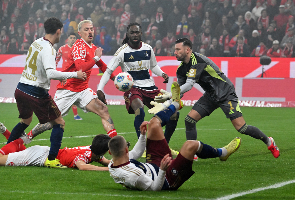 Mainz's Phillip Tietz, second left, and goalkeeper Hamburger's Daniel Heuer Fernandes, right, in action during the Bundesliga soccer match between Mainz 05 and Hamburger SV in Mainz, Germany, Friday Feb. 20, 2026. (Torsten Silz/dpa via AP)