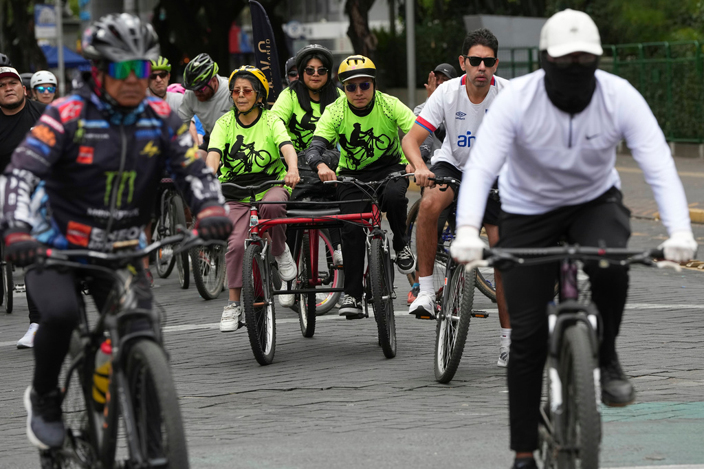 A volunteer with the "Ciegocleta" initiative guides a visually impaired participant, left, on a tandem bicycle in Quito, Ecuador, Sunday, Aug. 30, 2026. (AP Photo/Dolores Ochoa)