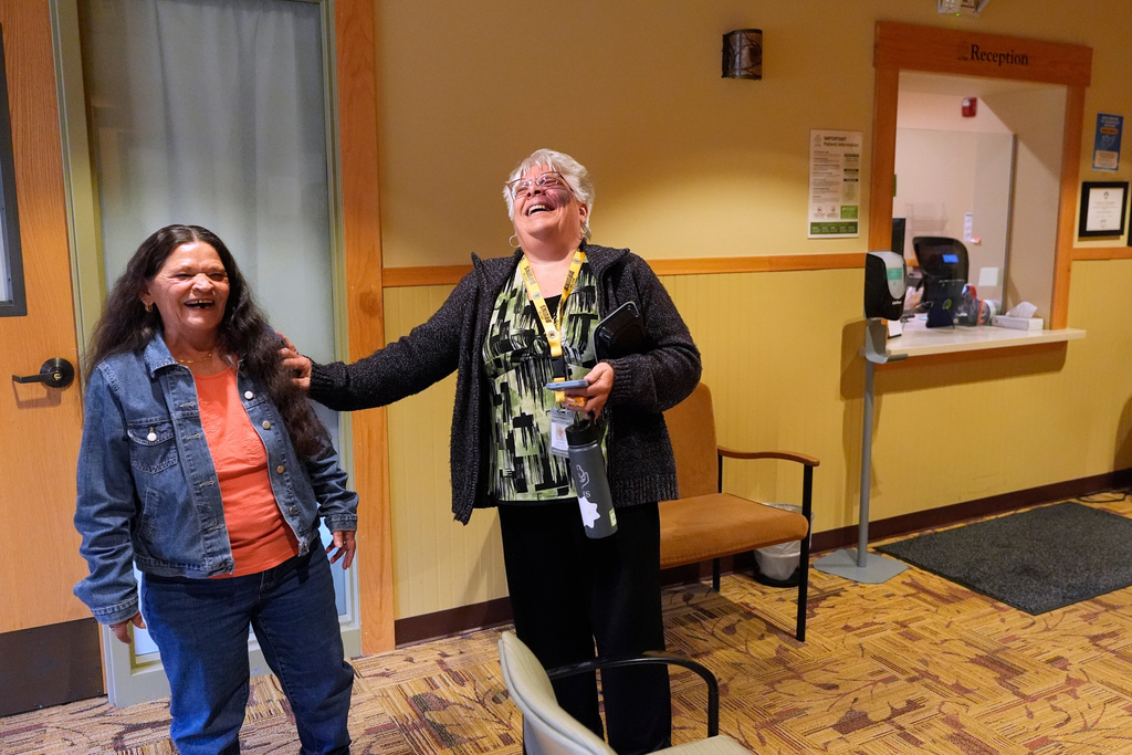 Receptionist Diane LaDuke, right, shares a laugh with longtime patient Susan Bushby at Ammonoosuc Community Health Services, Tuesday, Oct. 21, 2025, in Franconia, N.H. (AP Photo/Robert F. Bukaty)