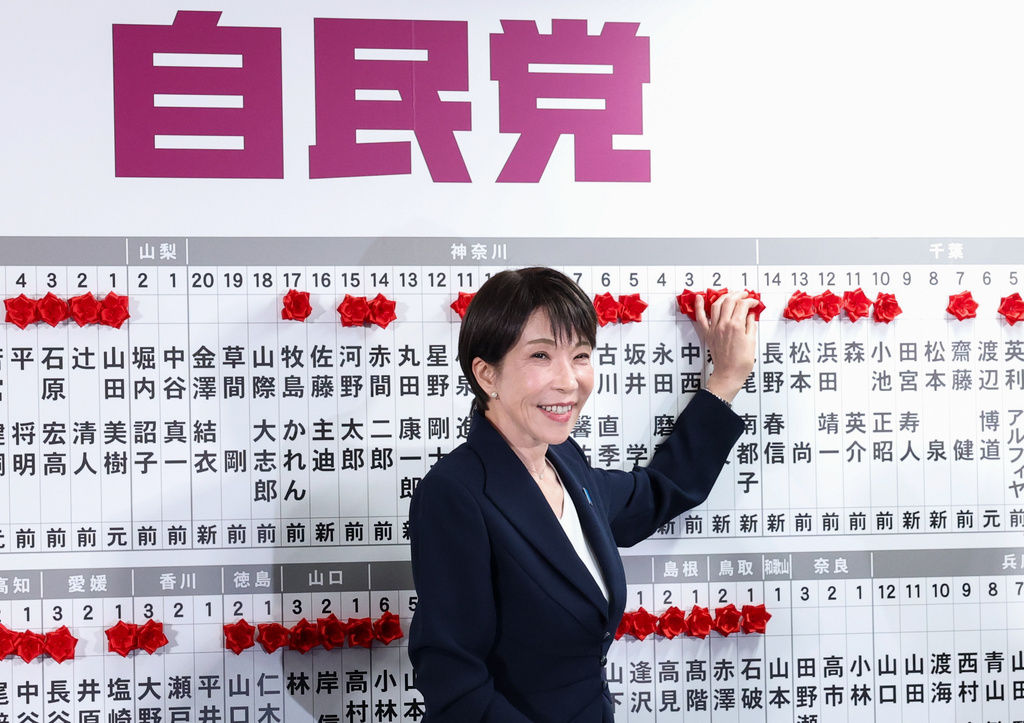 Sanae Takaichi, center, Japan's prime minister and president of the ruling Liberal Democratic Party (LDP), puts pins marking the names of candidates who won lower house elections, at the LDP headquarters Sunday, Feb. 8, 2026 in Tokyo, (Kim Kyung-Hoon/Pool Photo via AP)
