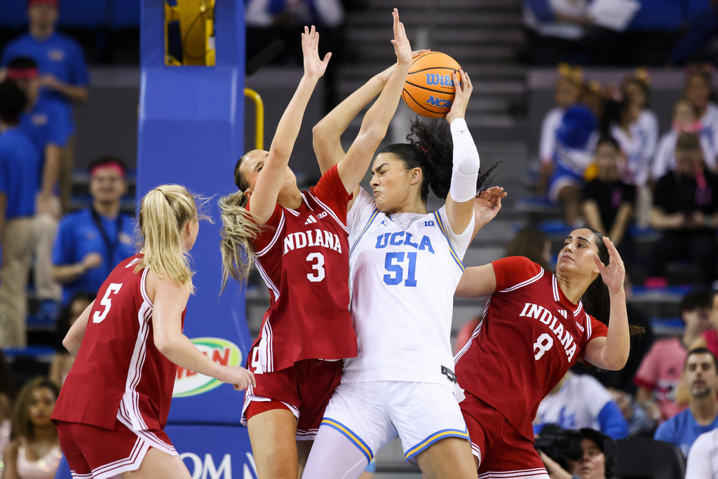 UCLA center Lauren Betts (51) possesses the ball against Indiana forwards Maya Makalusky (3) and Edessa Noyan (8) as Indiana guard Lenée Beaumont (5) watches during the first half of an NCAA college basketball game, Sunday, Feb. 15, 2026, in Los Angeles. (AP Photo/Jessie Alcheh)