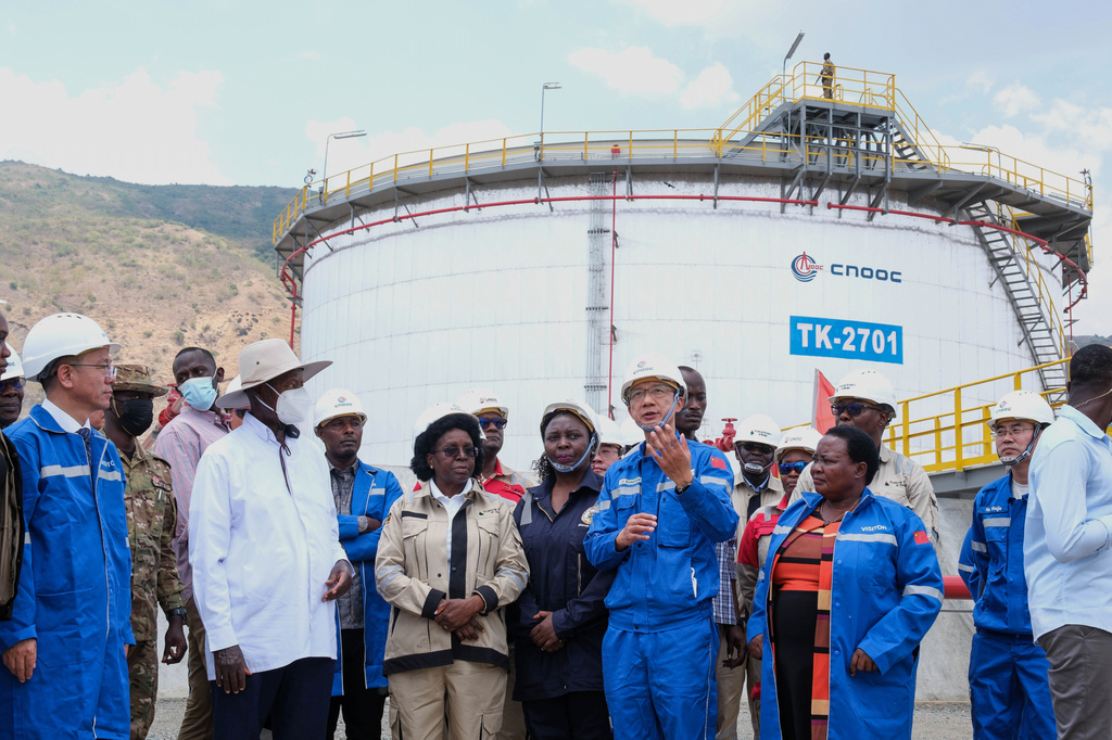 CNOOC President Dr. Liu Xiangdong, center, talks to Ugandan President Yoweri Museveni during a tour of the central processing unit at the Kingfisher oil field near Hoima, Uganda, Wednesday, Sept. 2, 2026. (AP Photo/Hajarah Nalwadda)