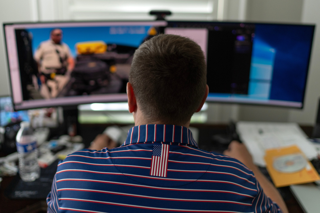 Alek Schott watches police body camera video of his vehicle search, Thursday, Oct. 16, 2025, while sitting at his home in Houston. (AP Photo/David Goldman)