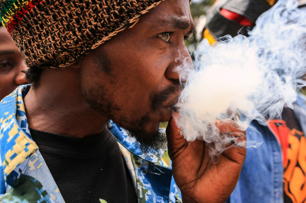 A Rastafarian smokes as they gather outside Milimani Law Courts, after the high court dismisses Rastafarian case seeking to legalize marijuana, in Nairobi, Wednesday, July 15, 2026. (AP Photo/Andrew Kasuku)