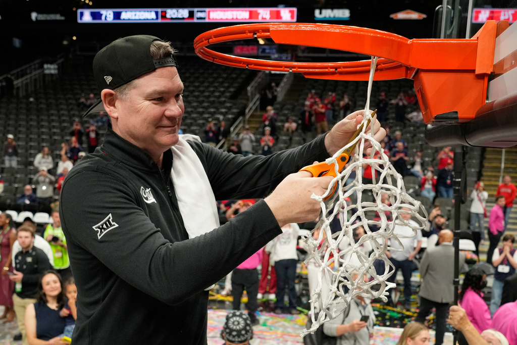 Arizona head coach Tommy Lloyd cuts down the net after winning an NCAA college championship basketball game at the Big 12 Conference tournament Saturday, March 14, 2026, in Kansas City, Mo. (AP Photo/Charlie Riedel)