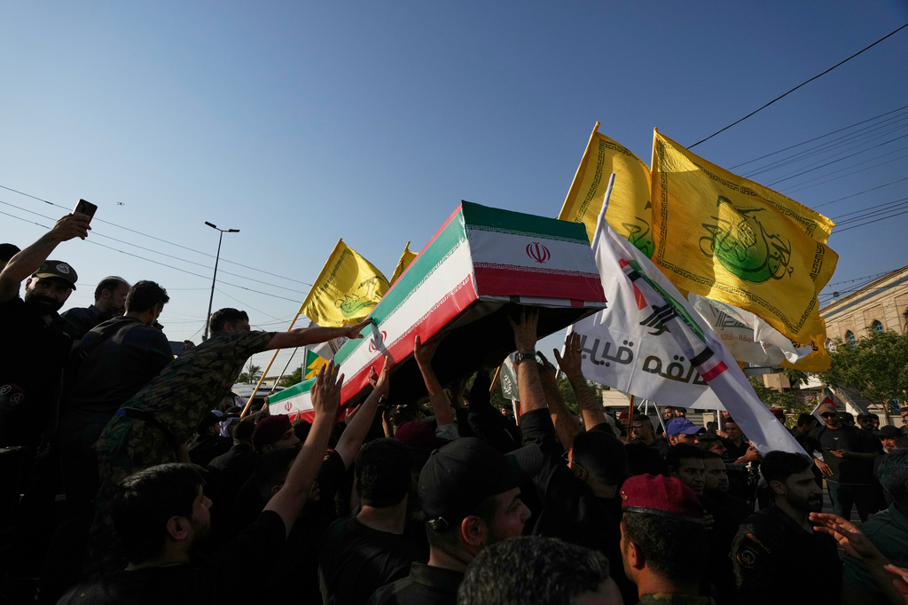 Mourners carry the coffin of an Iranian adviser draped in the Iranian flag during a group funeral for Iranian advisers and Popular Mobilization Forces fighters killed in airstrikes on bases belonging to Iraq's Popular Mobilization Forces, a coalition of predominantly Shiite militias that includes Iran-backed groups, in Mosul, Iraq, Wednesday, July 29, 2026. (AP Photo/Hadi Mizban)
