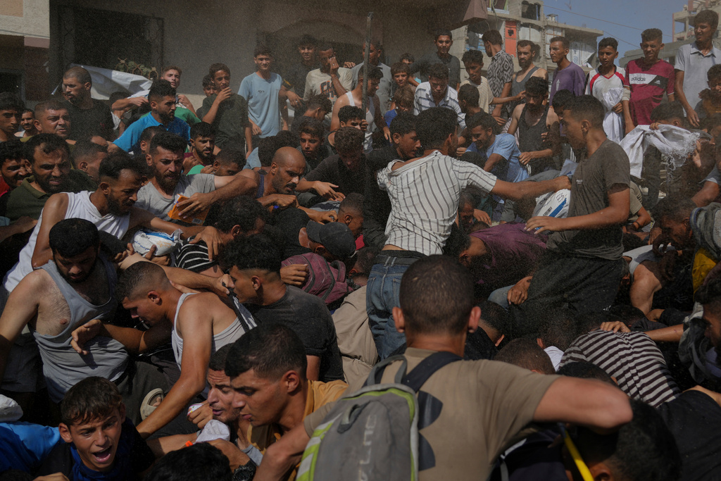 People struggle to collect humanitarian aid airdropped into Gaza City, northern Gaza Strip, Thursday, Aug. 14, 2025. (AP Photo/Jehad Alshrafi)