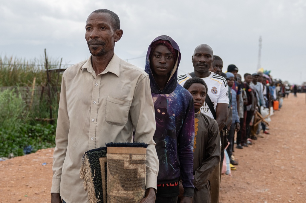 Burundian citizens who work in Uvira, Democratic Republic of the Congo, and could not cross back into their home country due to fighting, cross the border into Burundi, Sunday, Dec. 14, 2025. (AP Photo/Moses Sawasawa)