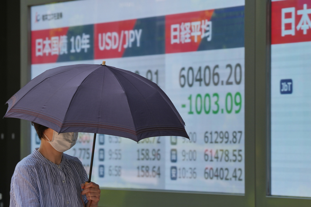 A person walks in front of an electronic stock board showing Japan's Nikkei index at a securities firm Monday, May 18, 2026, in Tokyo. (AP Photo/Eugene Hoshiko)